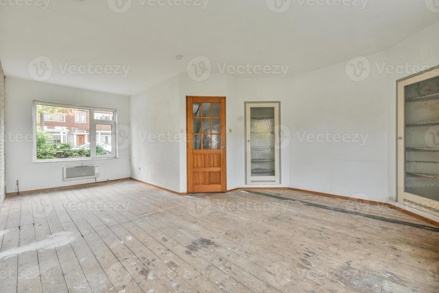 An empty room with wood floors and a door photo