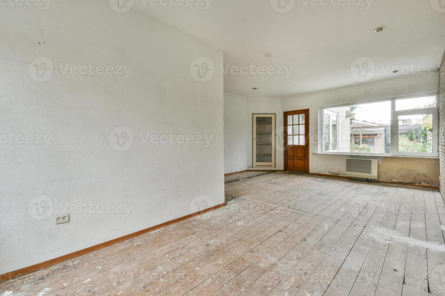An empty room with wood floors and a window photo