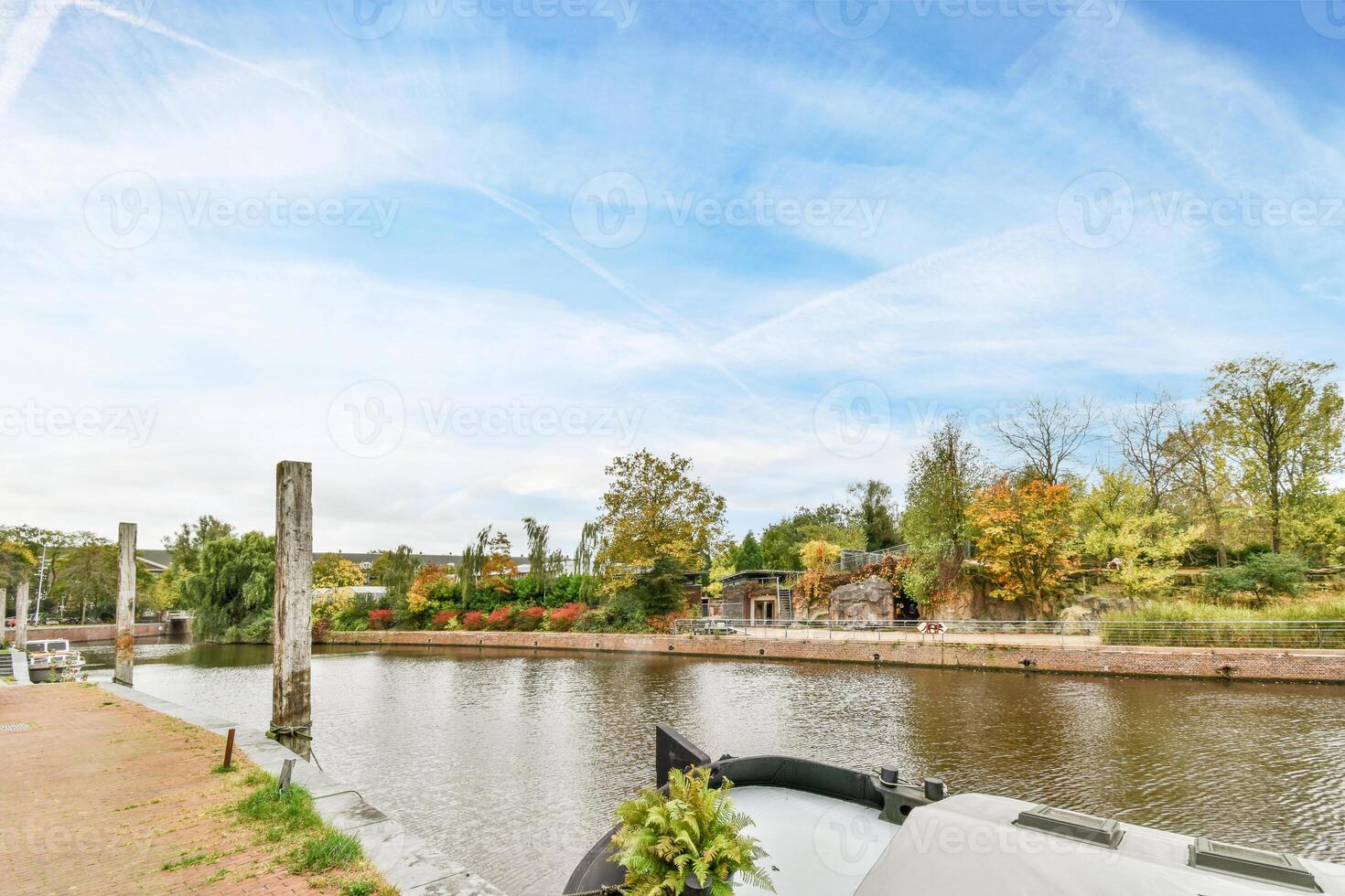 A boat is docked on the side of a canal photo