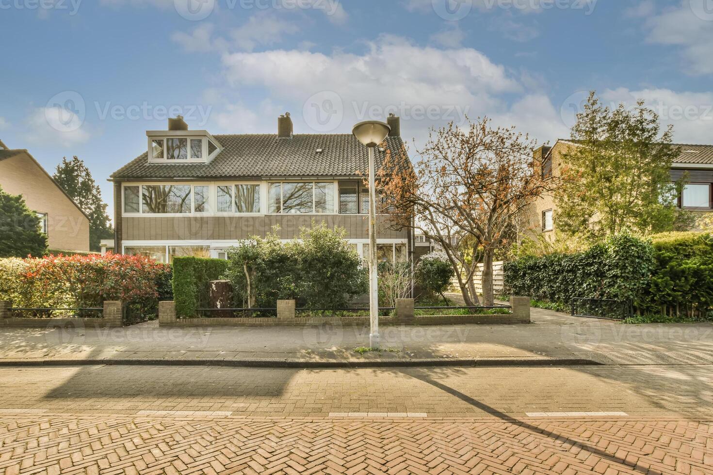 A house with a brick sidewalk and trees in the background photo