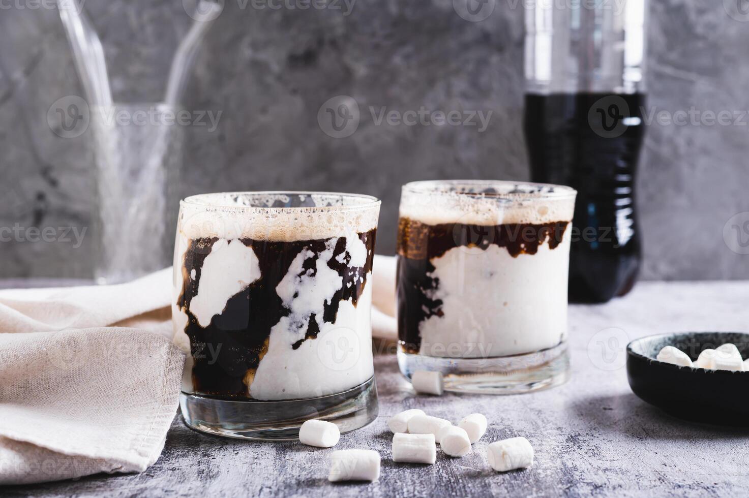 Fusion drink of cola and marshmallow in glasses on the table photo