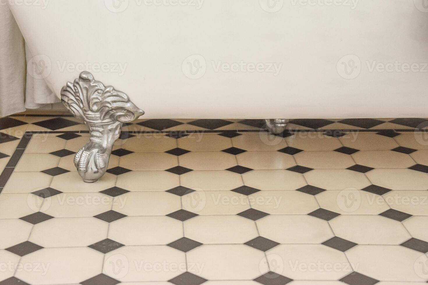 A white bathtub with black and white tiles photo