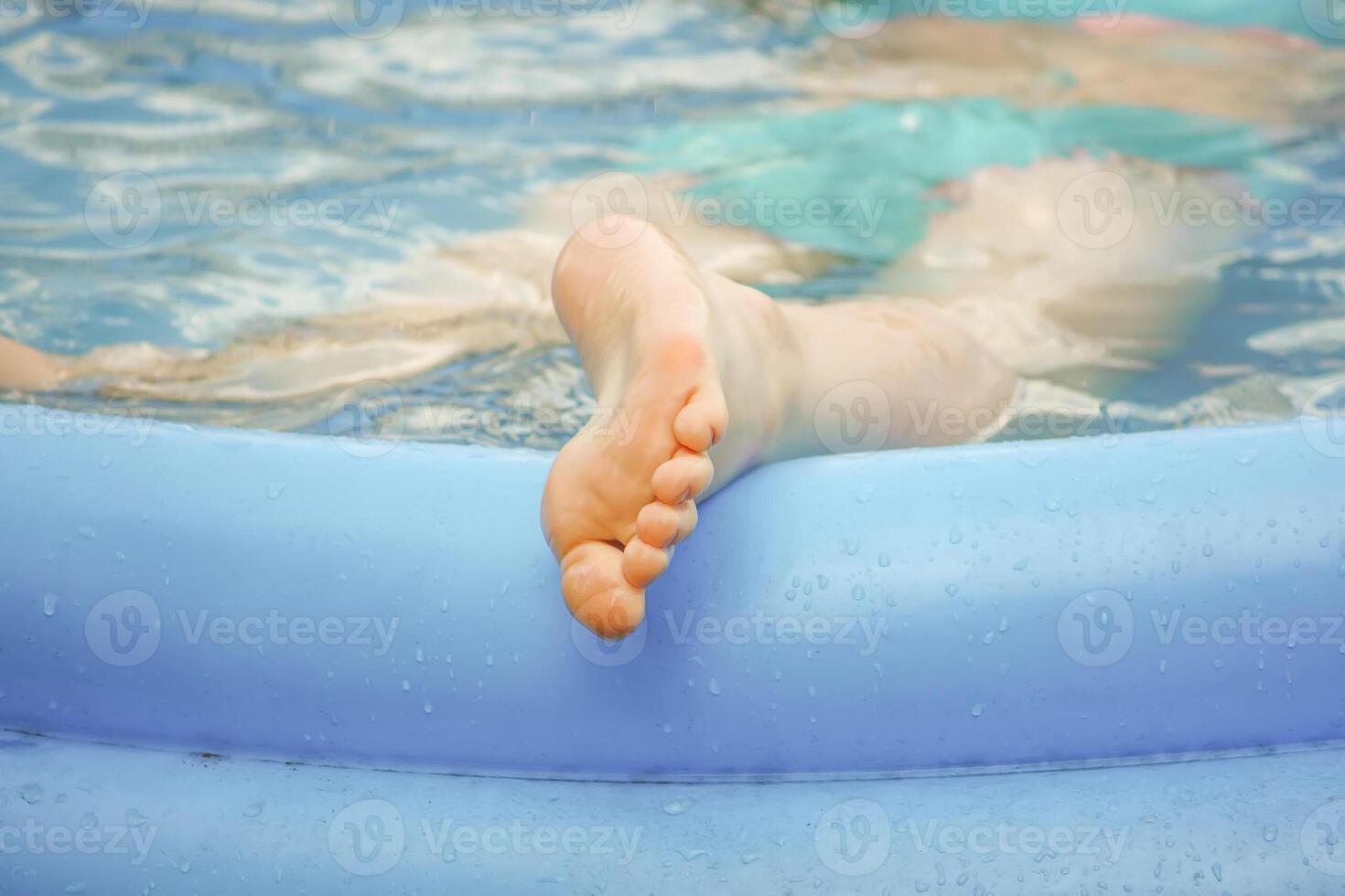Little girl playing in swimming pool outdoors at summer. photo