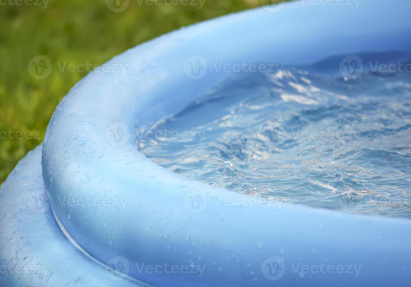 Little girl playing in swimming pool outdoors at summer. photo