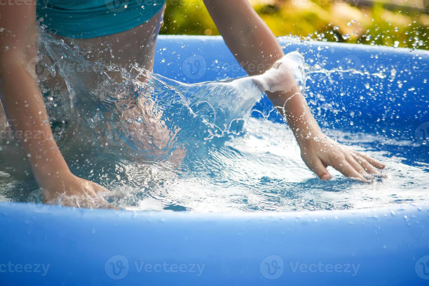 Little girl playing in swimming pool outdoors at summer. photo