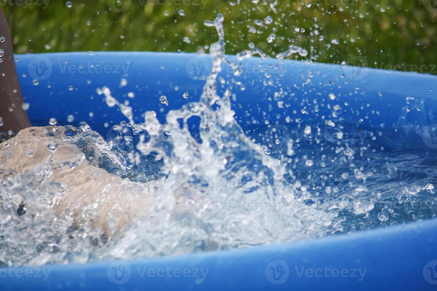 Little girl playing in swimming pool outdoors at summer. photo
