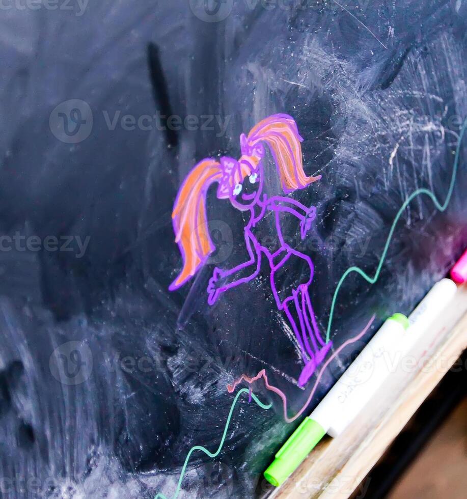 Child's drawing by colored marker on blackboard photo