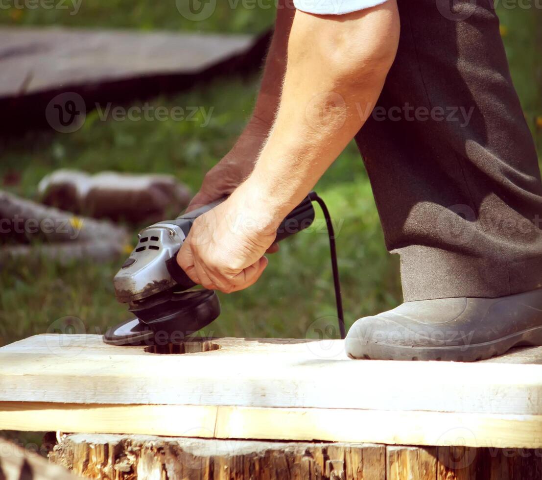 Hands of a man taking measurement of a wooden plank photo
