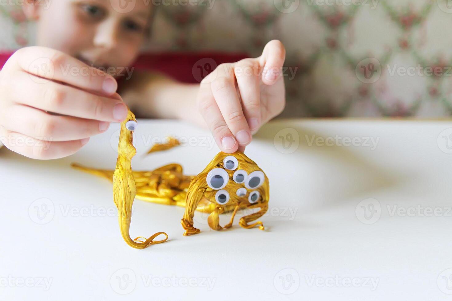 Child playing with a gold slime photo