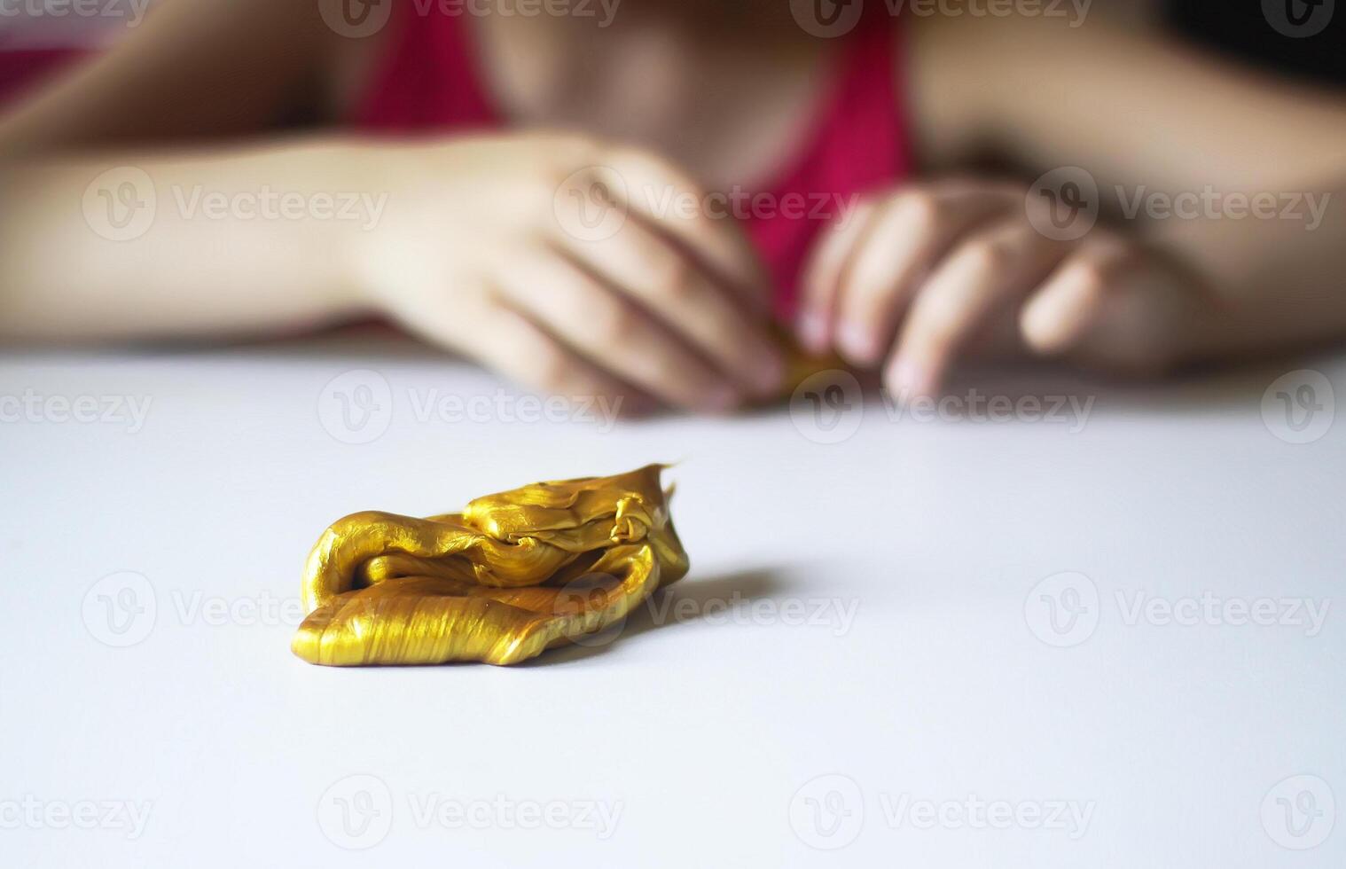 Child playing with a gold slime photo