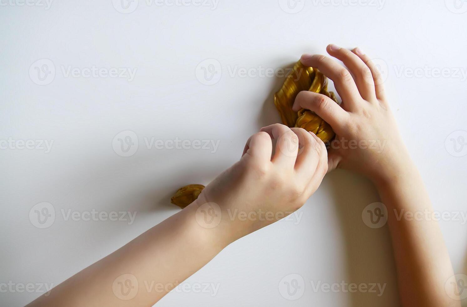 Child playing with a gold slime photo