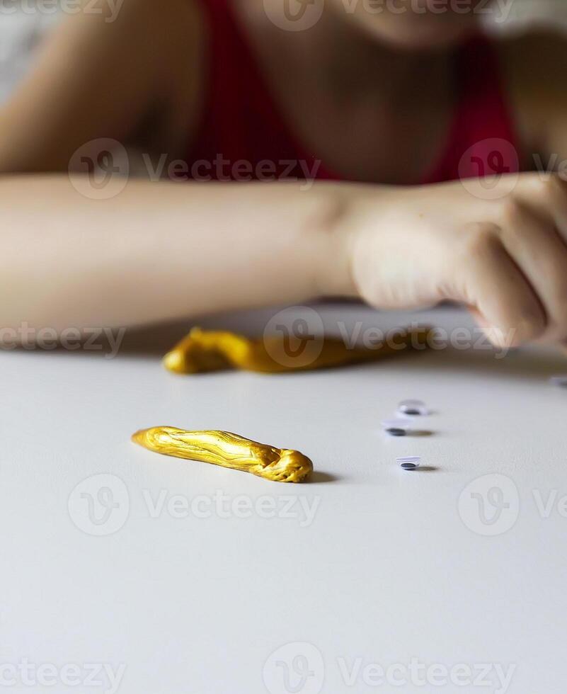 Child playing with a gold slime photo