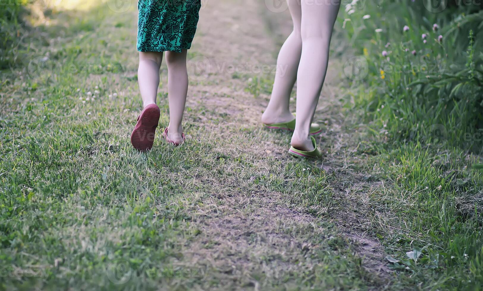 A child's legs running on summer grass. photo