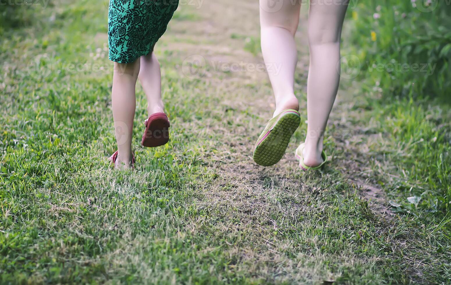 A child's legs running on summer grass. photo