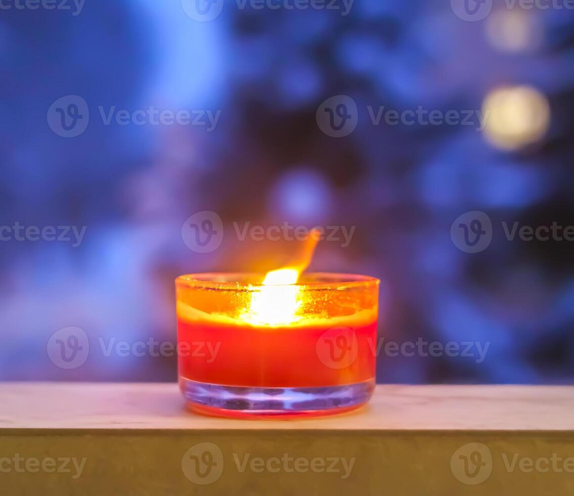 Burning red candle on winter background. photo