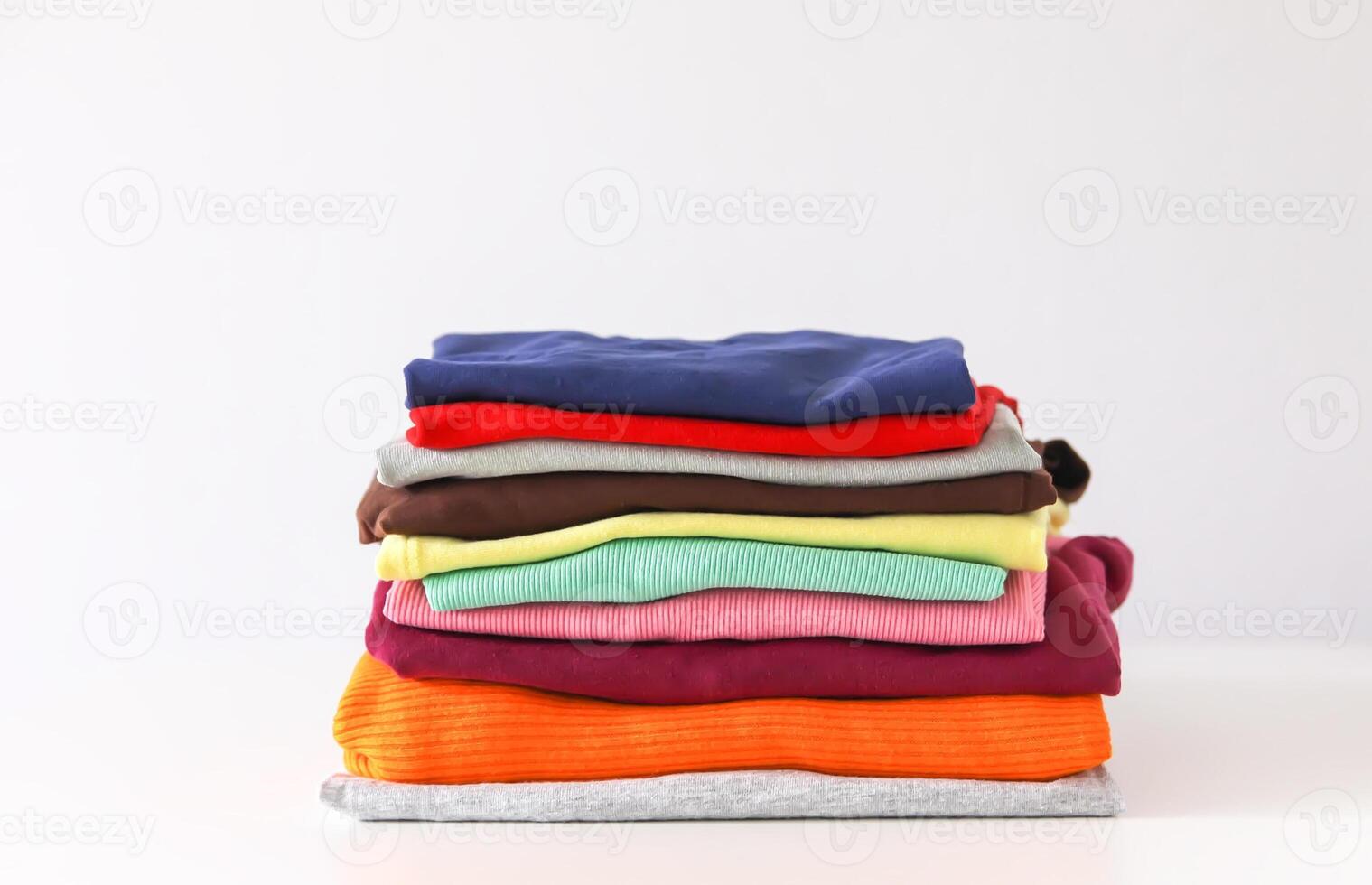 Stack of folded colorful clothes. Compact storage organizing photo