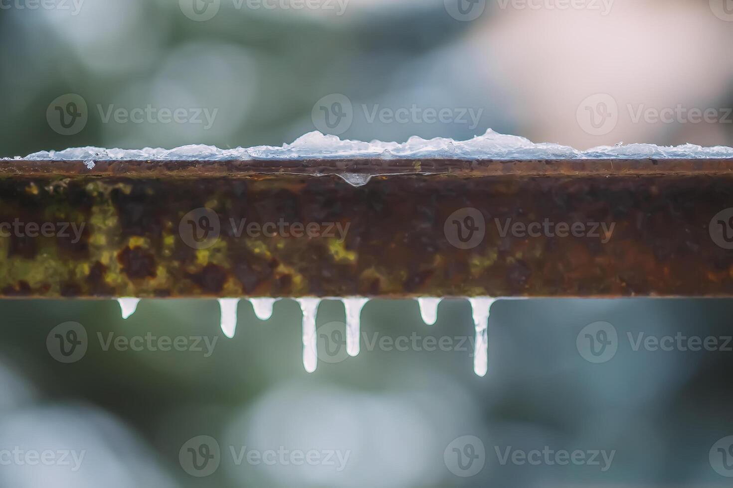 Icicles hanging on metal railing. photo