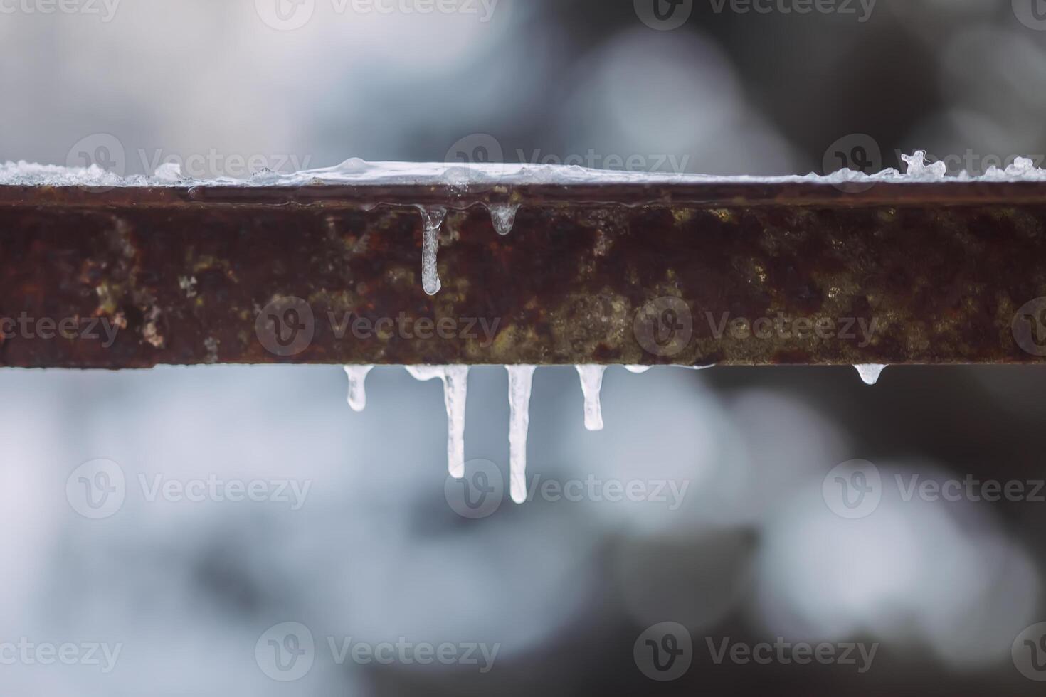 Icicles hanging on metal railing. photo
