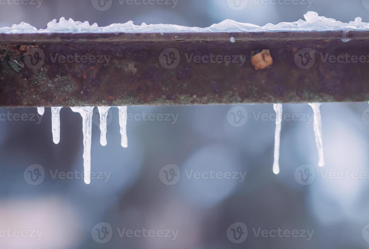 Icicles hanging on metal railing. photo