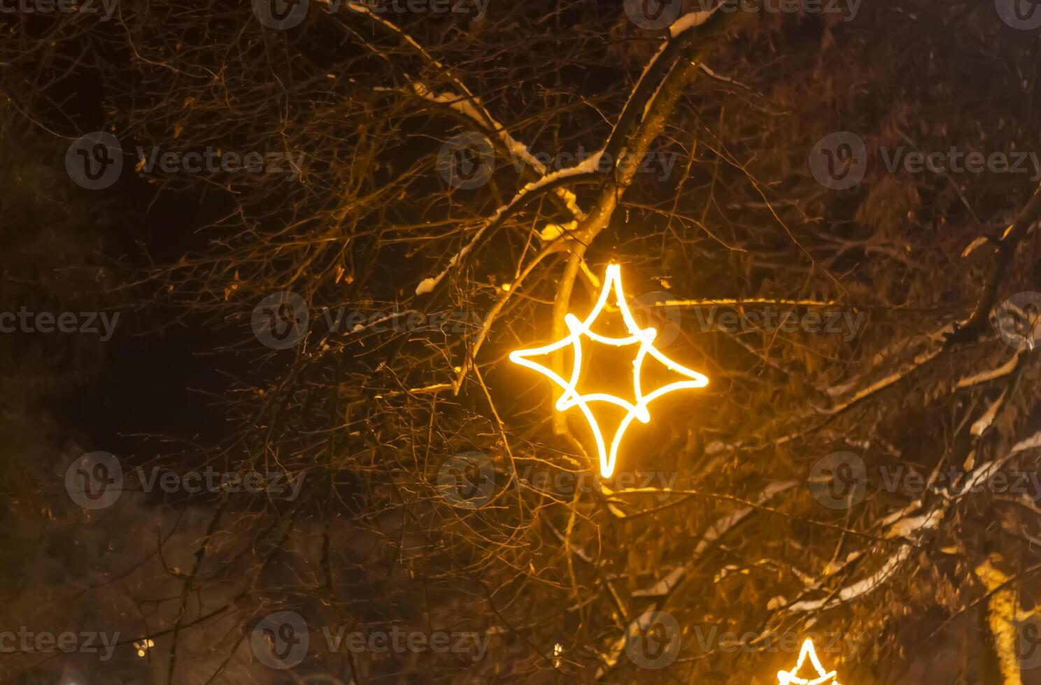 Christmas street with decorative garlands on tree branches and glowing light bulbs. photo