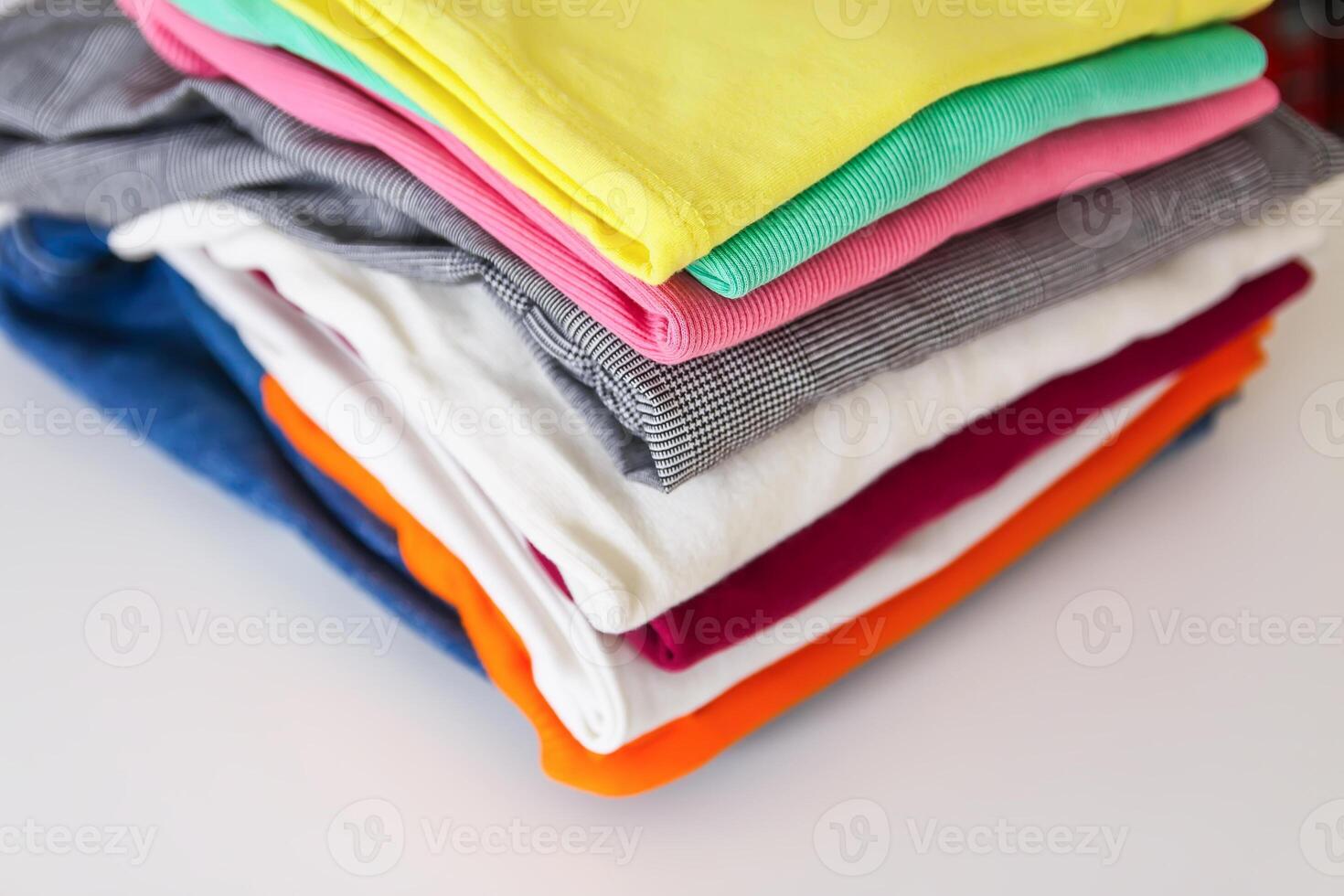 Stack of folded colorful clothes. Compact storage organizing photo