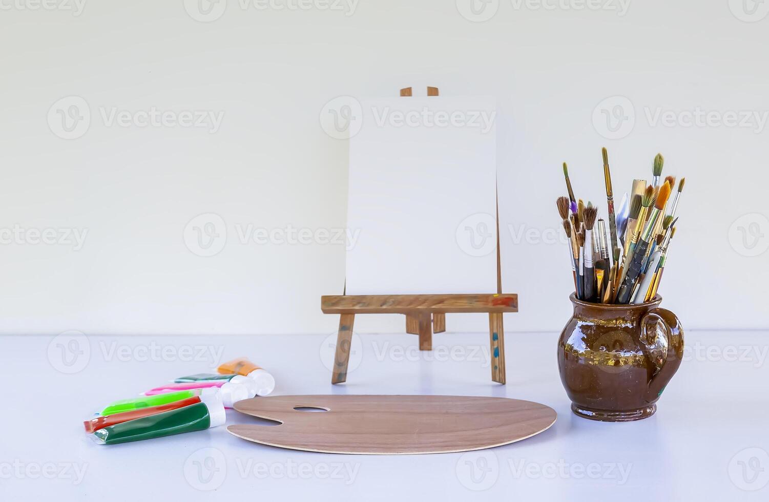 Artist's workplace. Canvas, paints, brushes and palette. photo