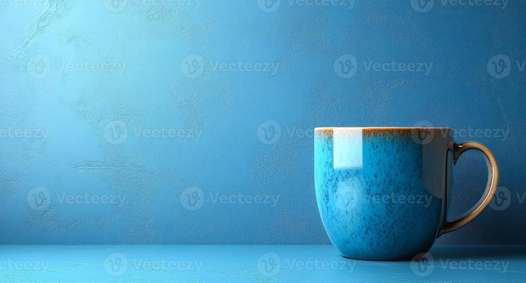 A blue mug sits on a countertop in front of a blue wall photo