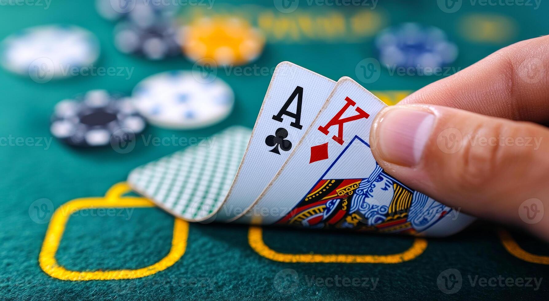 A hand holding a deck of cards with the Ace of Hearts and King of Diamonds. The cards are on a green table photo
