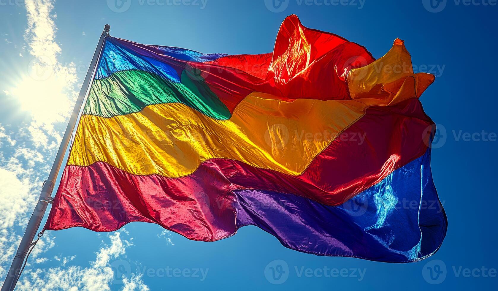 A rainbow flag is flying in the sky. The flag is colorful and has a rainbow pattern. The sky is clear and blue, and the sun is shining brightly. The flag is waving in the wind photo