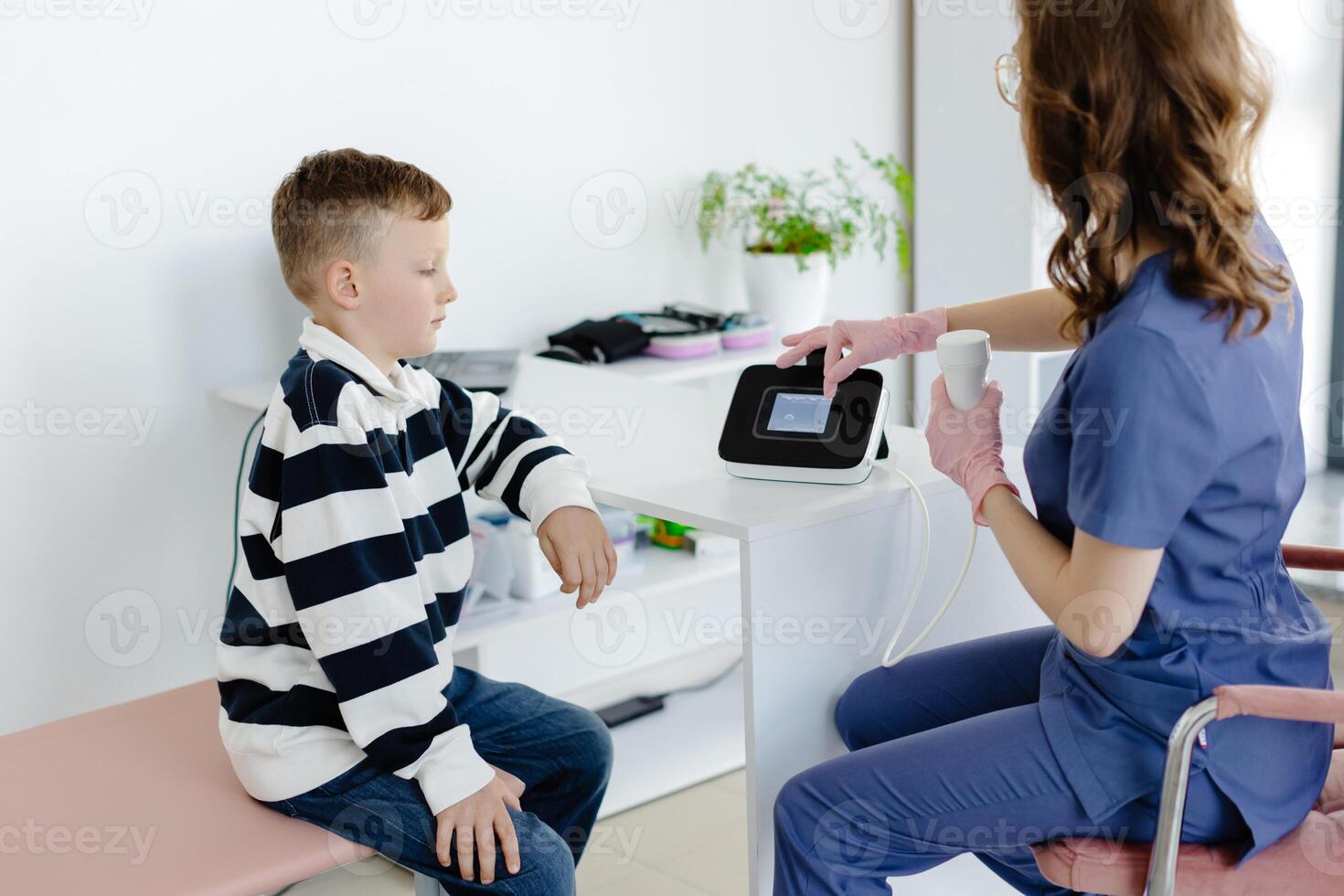 Boy testing breathing function by spirometry in doctors office. Diagnosis of respiratory function in pulmonary disease photo