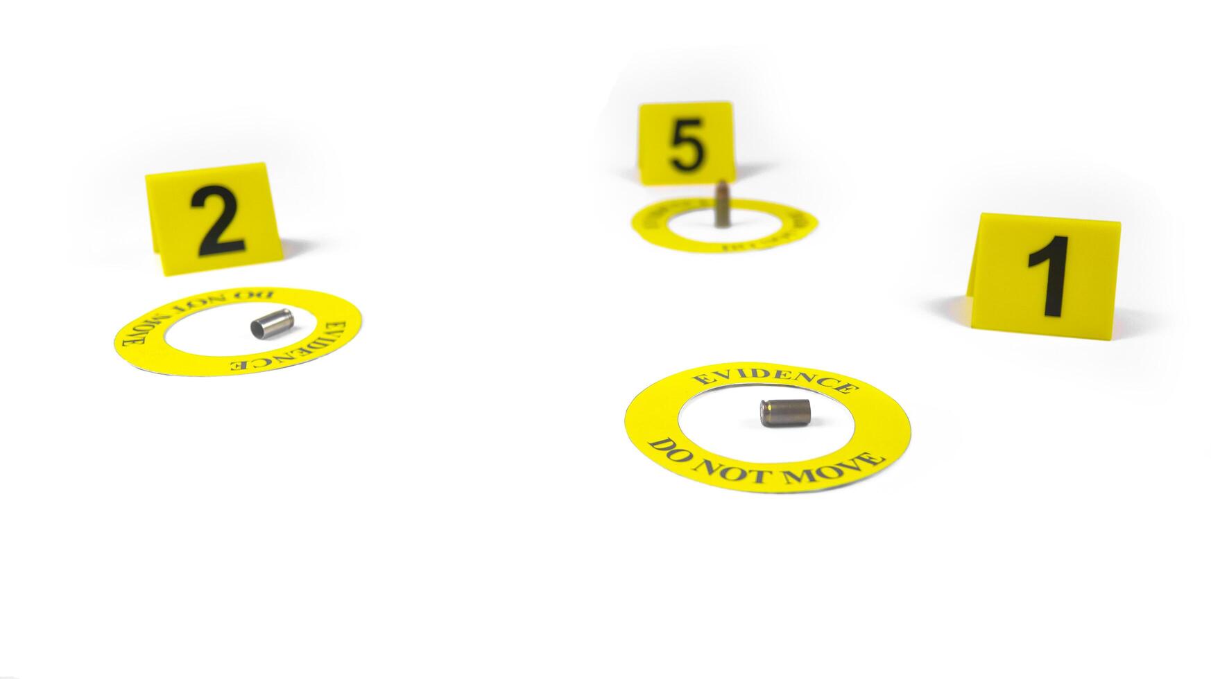 A spent bullet casing placed within a yellow circle, labeled with the text Evidence, Do Not Move, with a blurred number 1,5 and 2 tag, set against a white background, concept of crime investigation. photo
