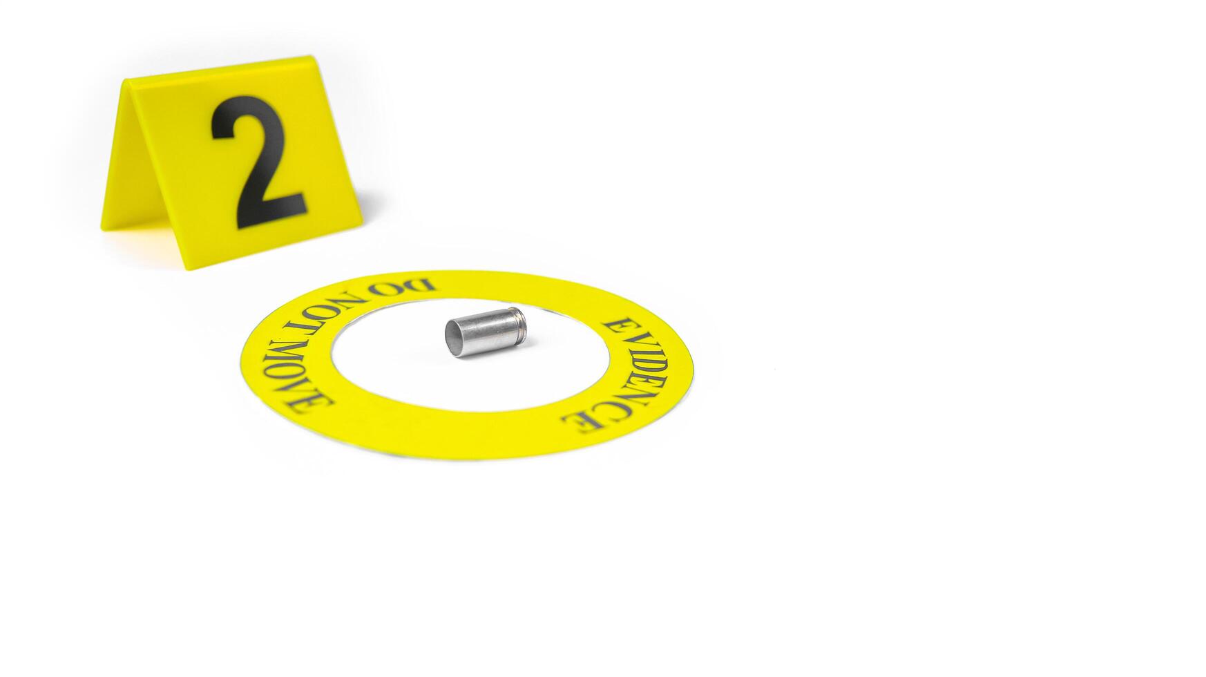 A spent bullet casing placed within a yellow circle, labeled with the text Evidence, Do Not Move, with a blurred number 2 tag, set against a white background, concept of crime investigation. photo