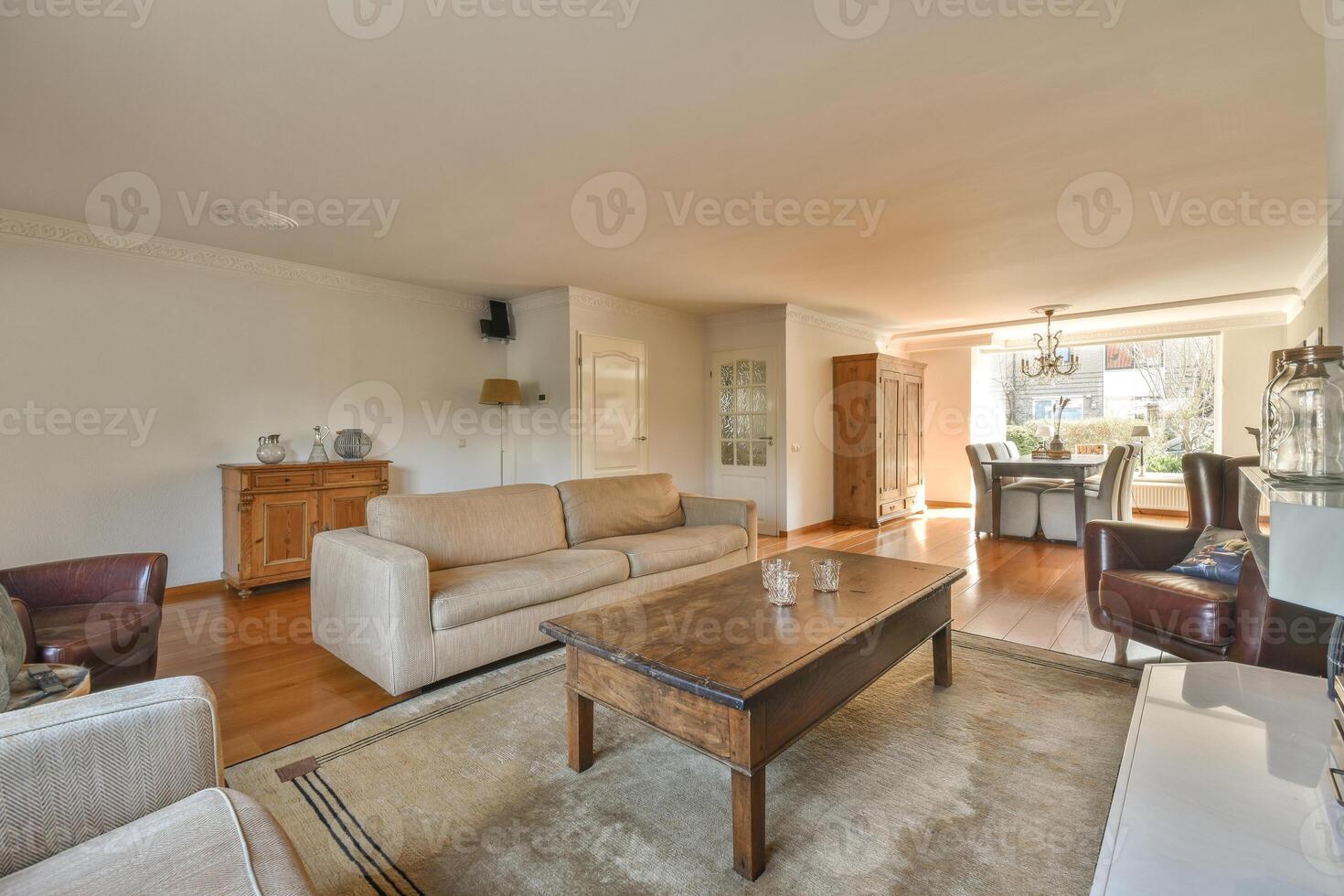 A living room with a couch, coffee table and a dining table photo