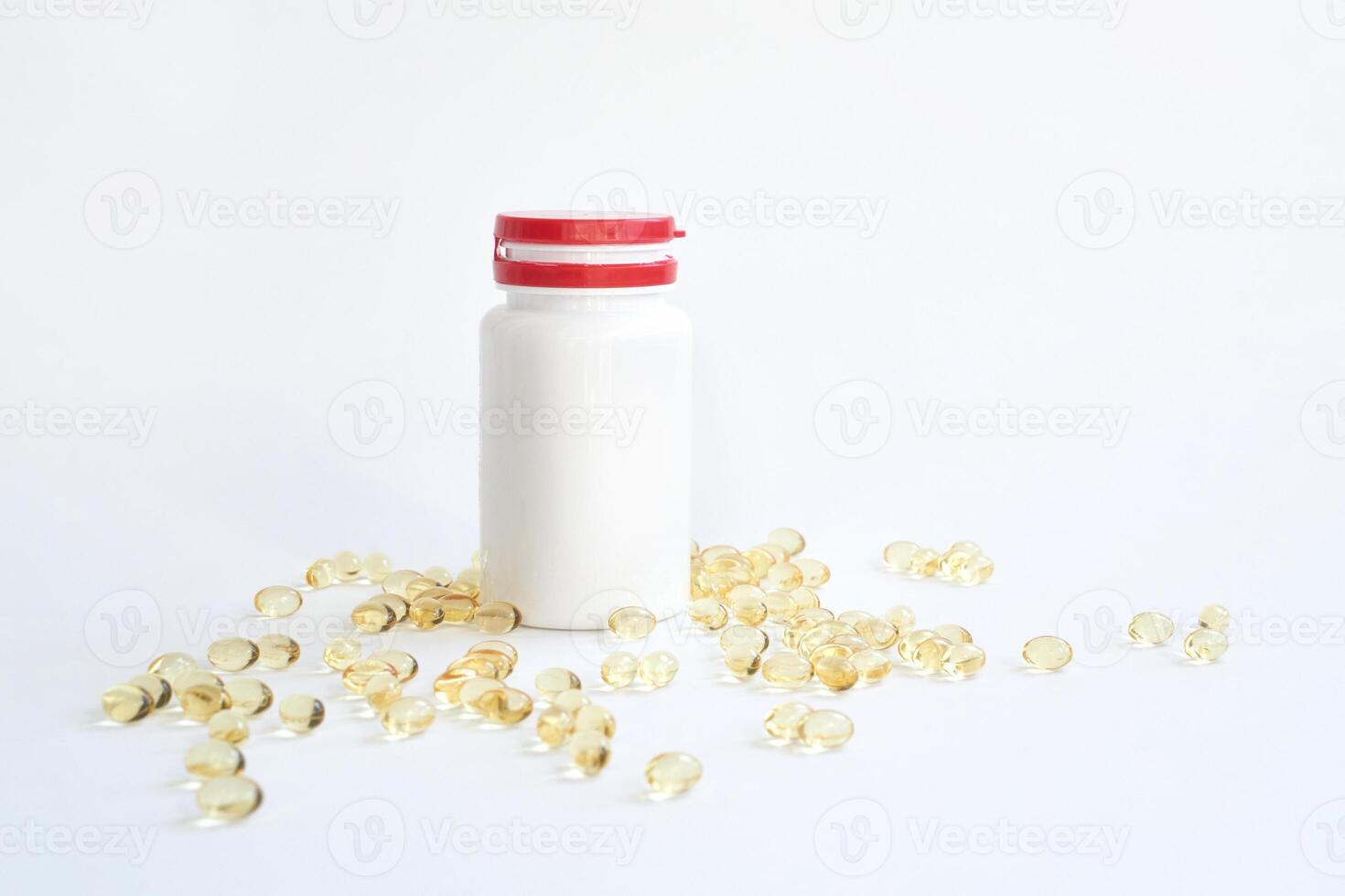 Clear gel capsules and white plastic bottle with red cap on white background for healthcare and medicine focused content photo