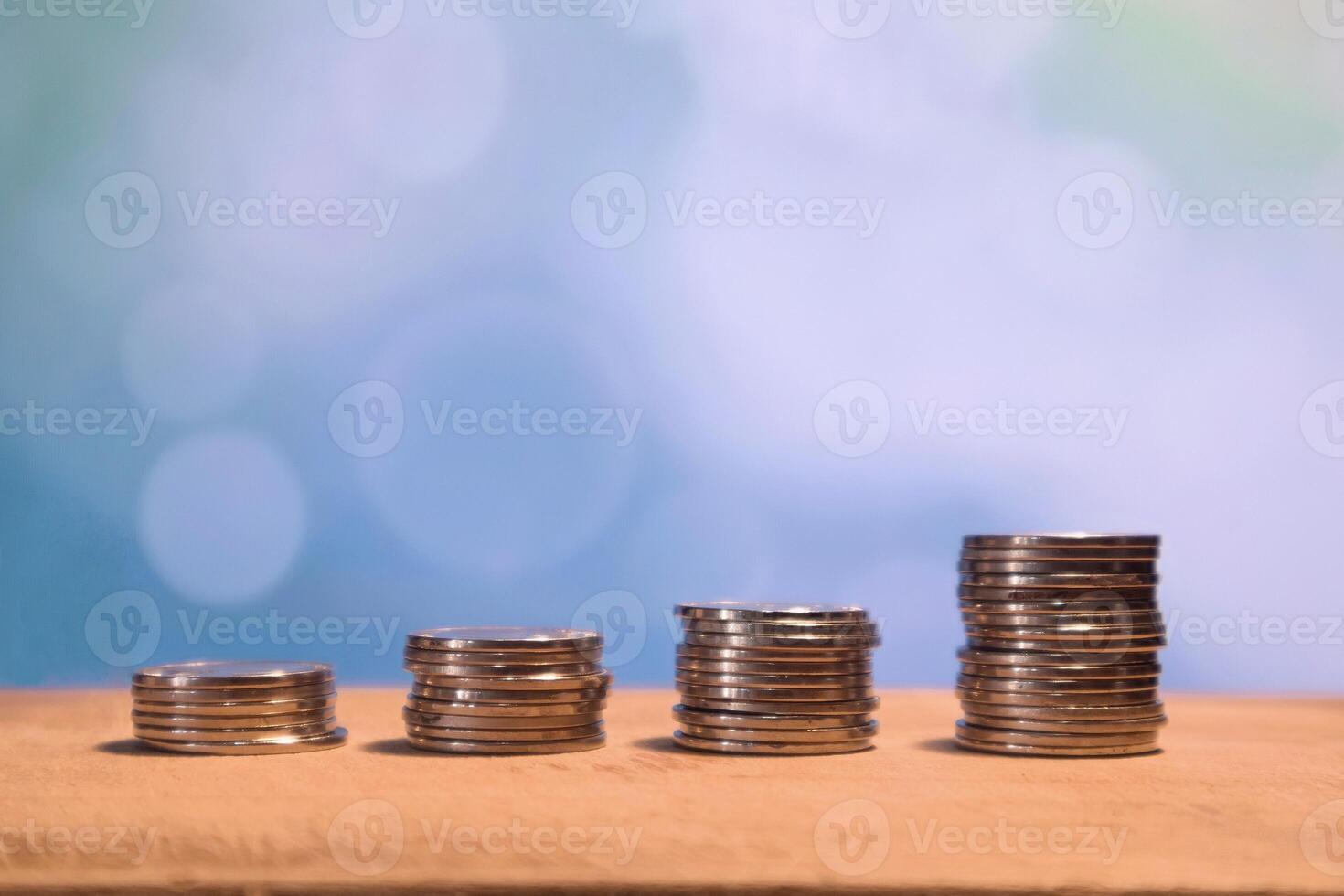 Stack of coins on a wooden table with nature background. Financial growth, Money saving, budget and investment concept. photo