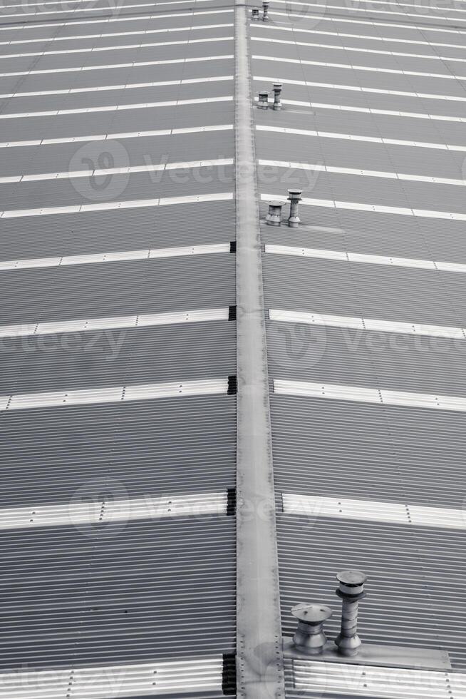 Monochrome view on industrial rooftop with geometric patterns created by the alignment of corrugated metal sheets. photo