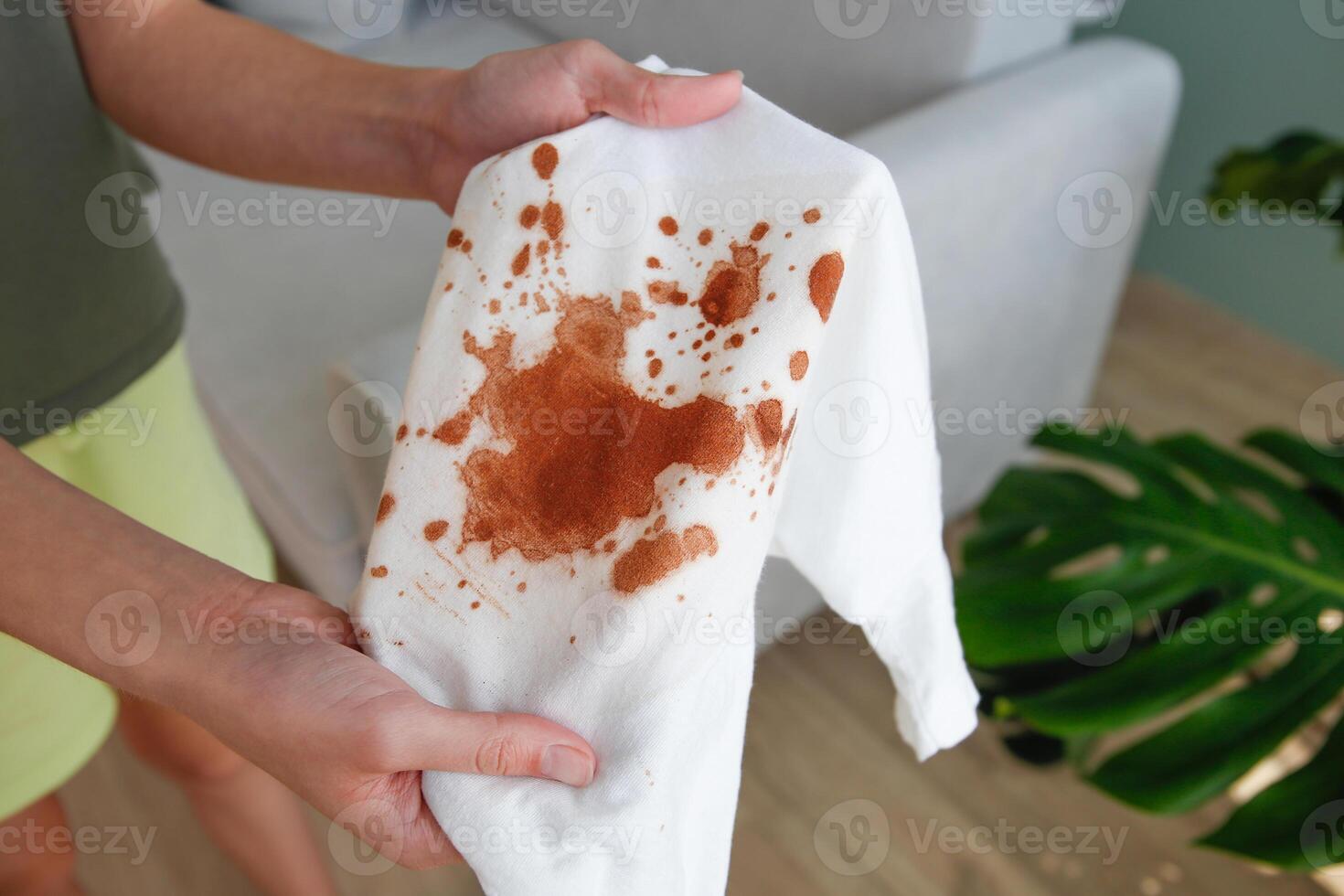The child spilled coffee on his clothes. The concept of a stain on a t-shirt. Top view. photo