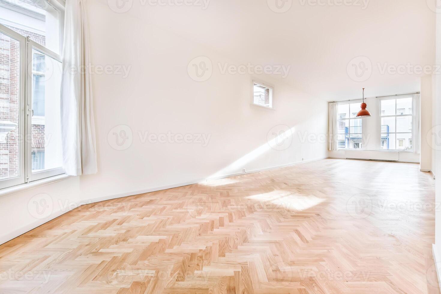 An empty room with hardwood floors and windows photo