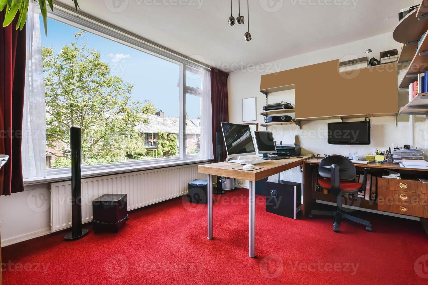 A home office with a desk, computer and a window photo