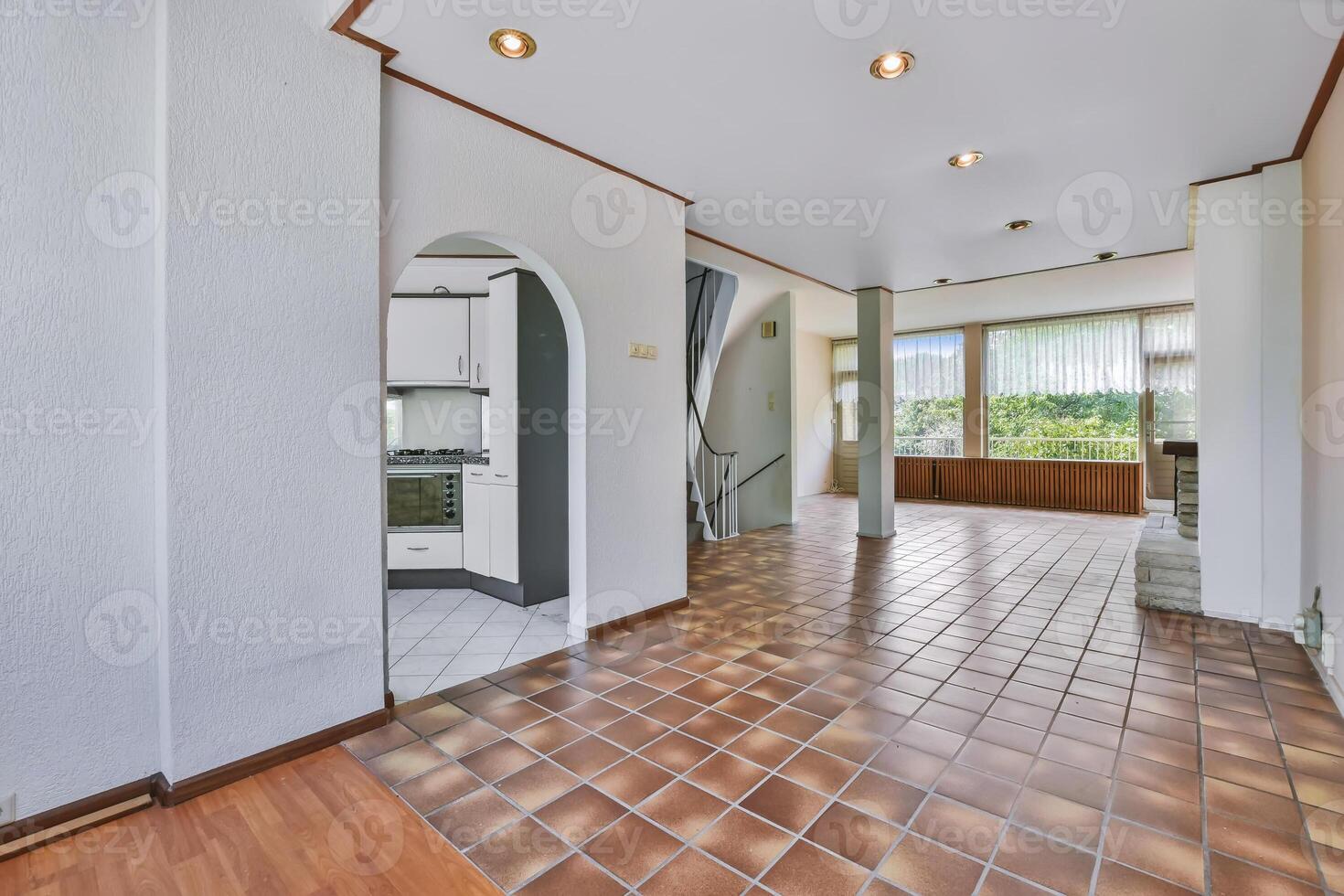 A hallway with a door and tile flooring photo
