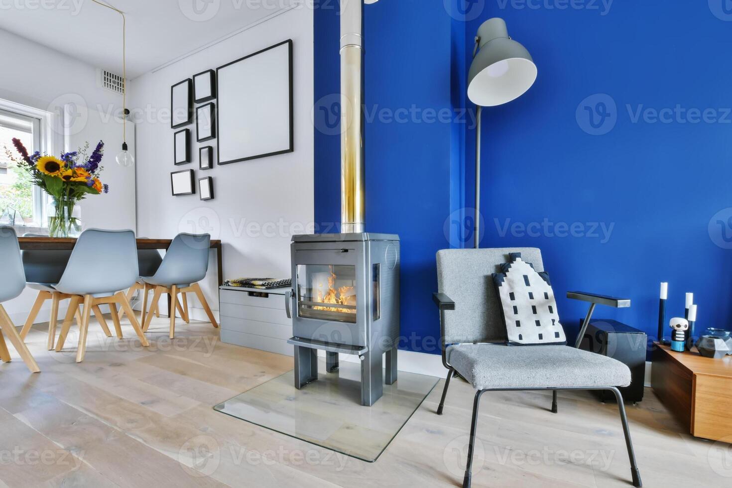 A blue wall with a wood burning stove in the middle of the room photo