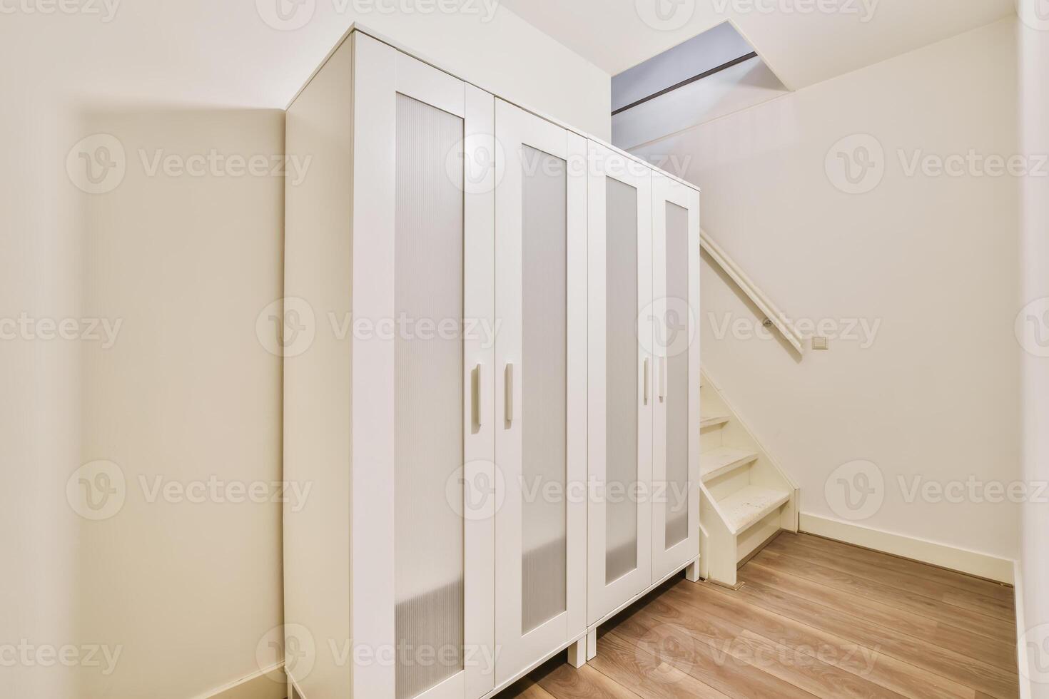 A white wardrobe with doors and a staircase photo