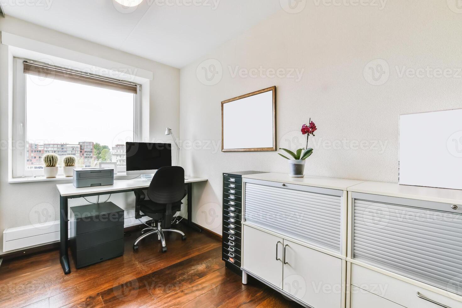 A home office with a desk, computer and a window photo