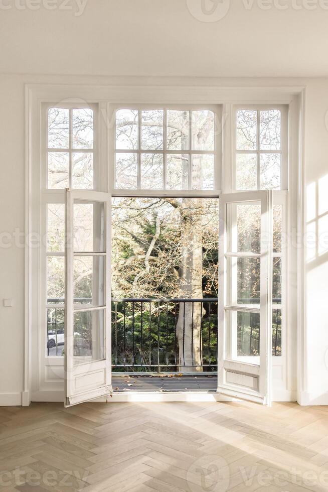 A room with a large window and wooden floor photo