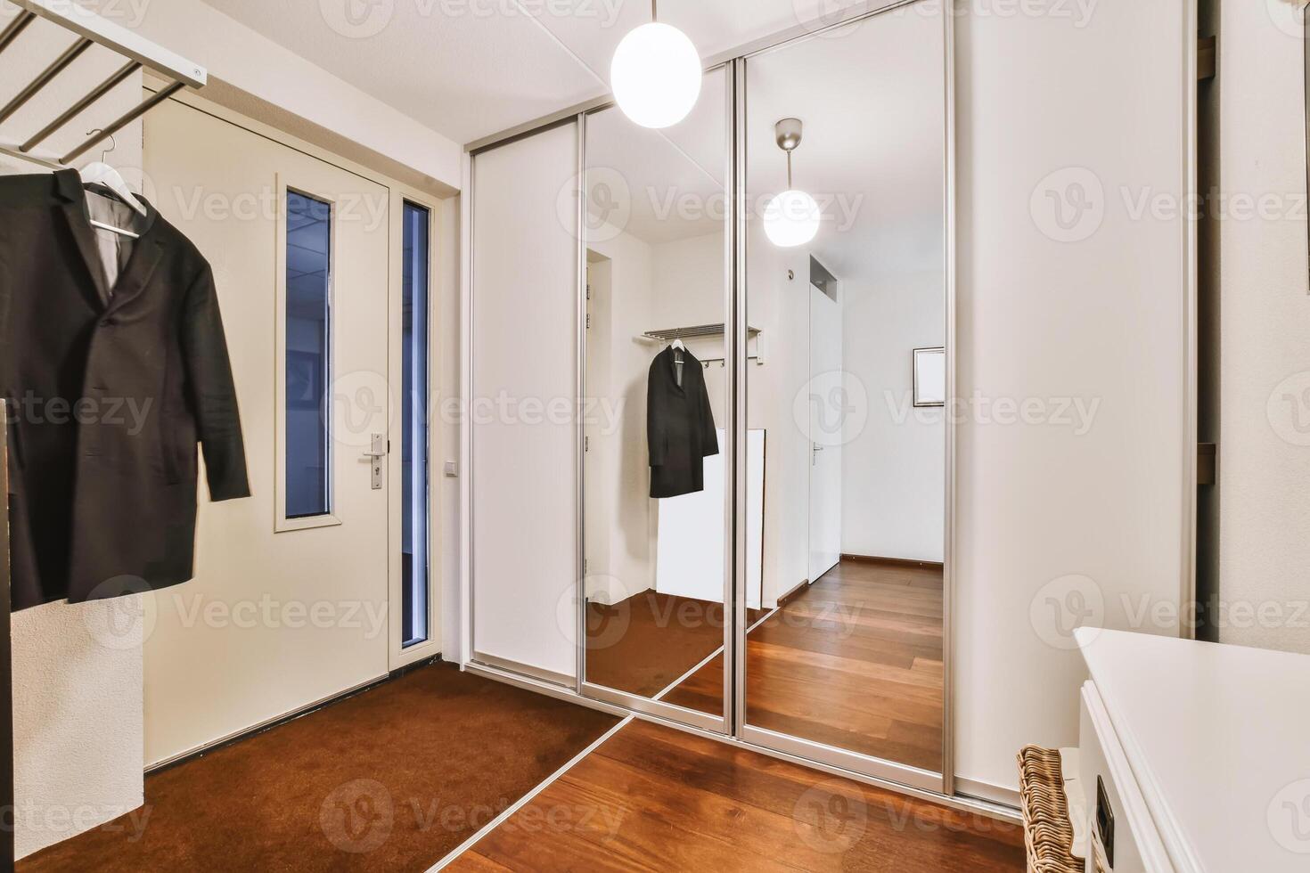 A hallway with a coat rack and a mirror photo