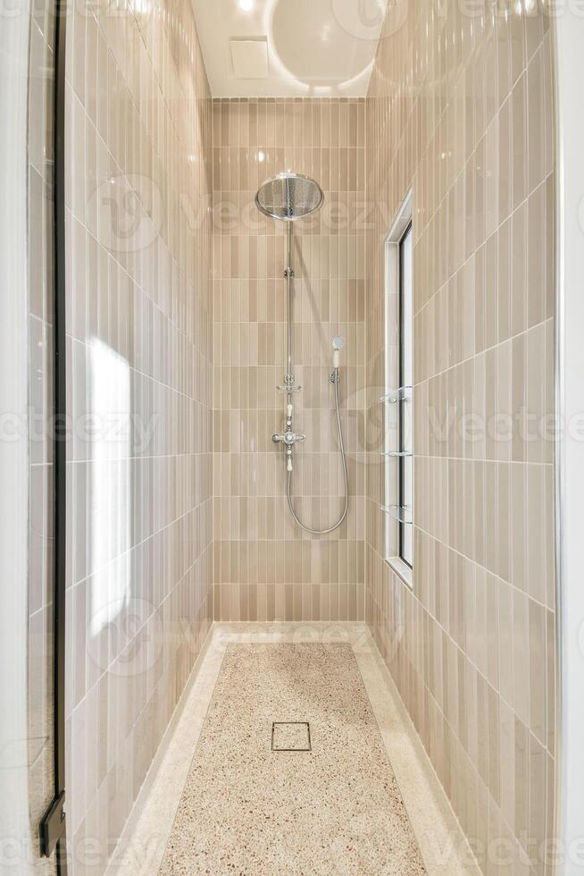 A shower with a glass door and tile walls photo