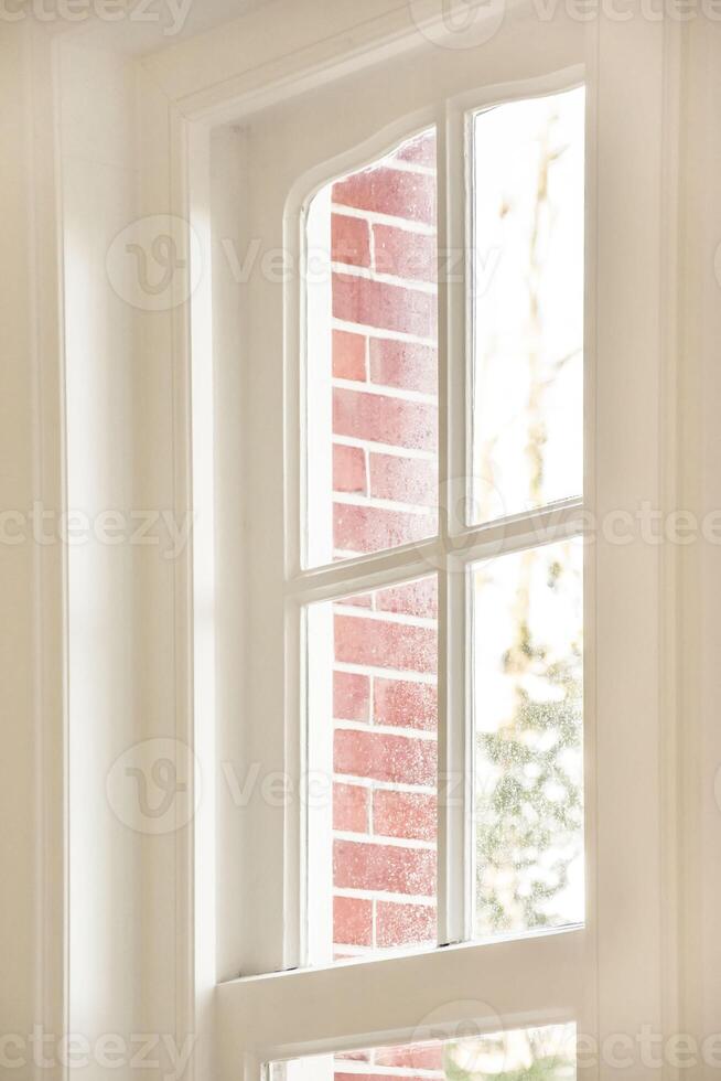 A window with a white frame and a brick wall photo