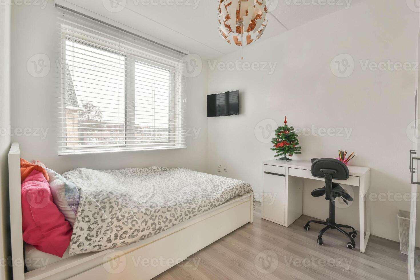 A bedroom with a desk and a bed in it photo