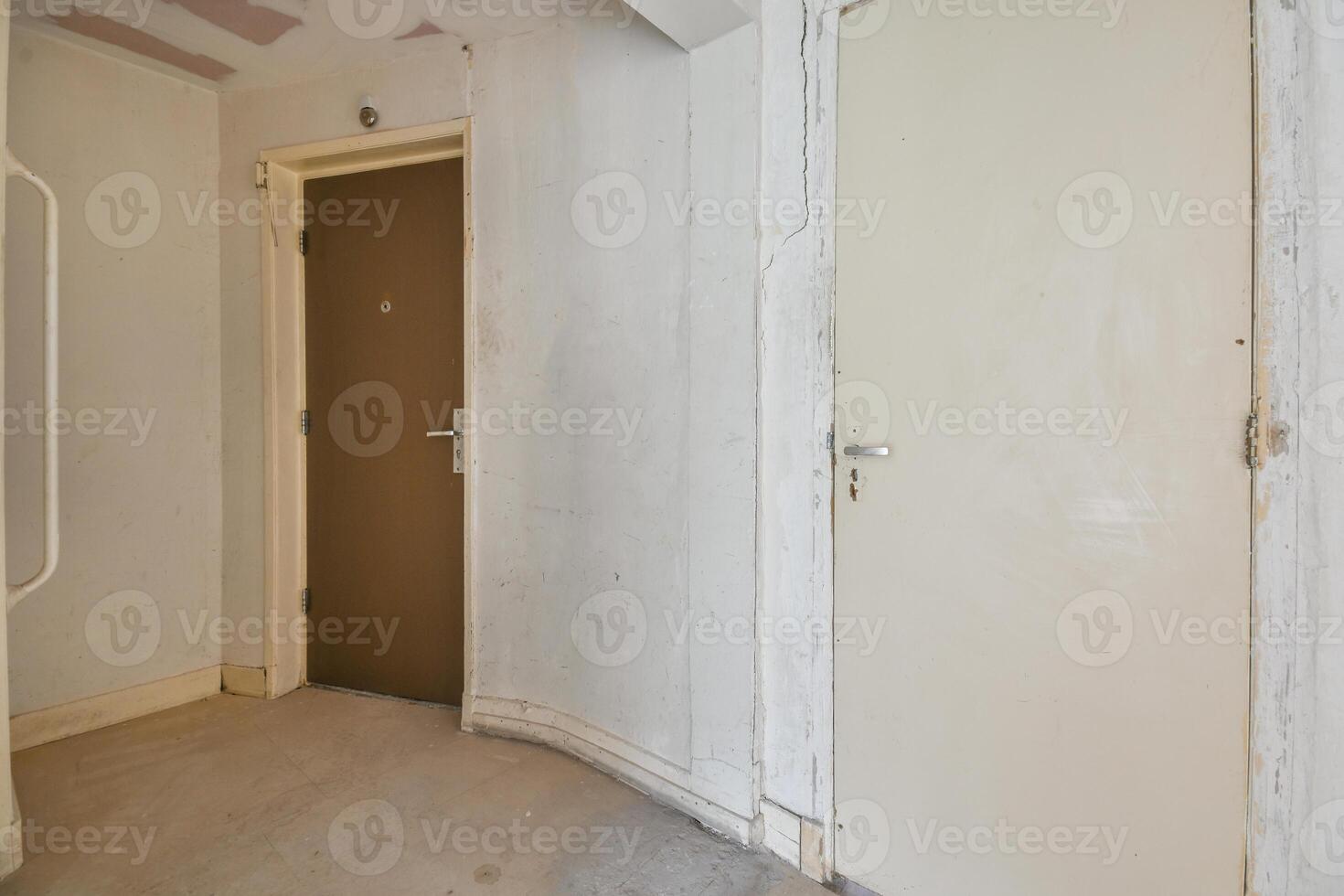 An empty room with a door and a wall photo
