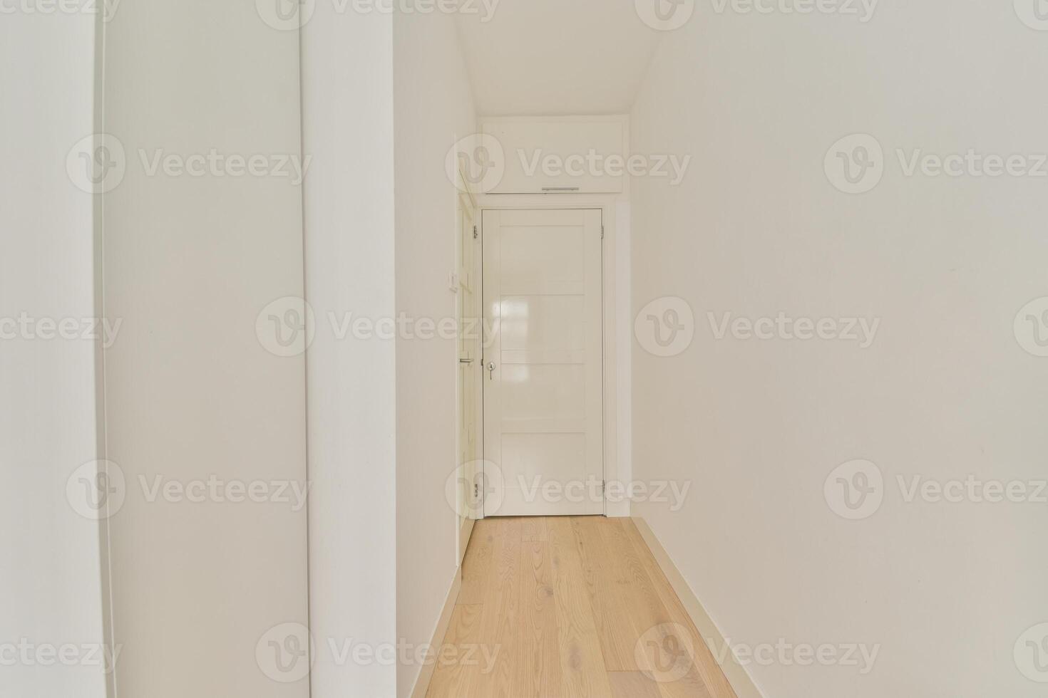 A hallway with white walls and wooden floors photo
